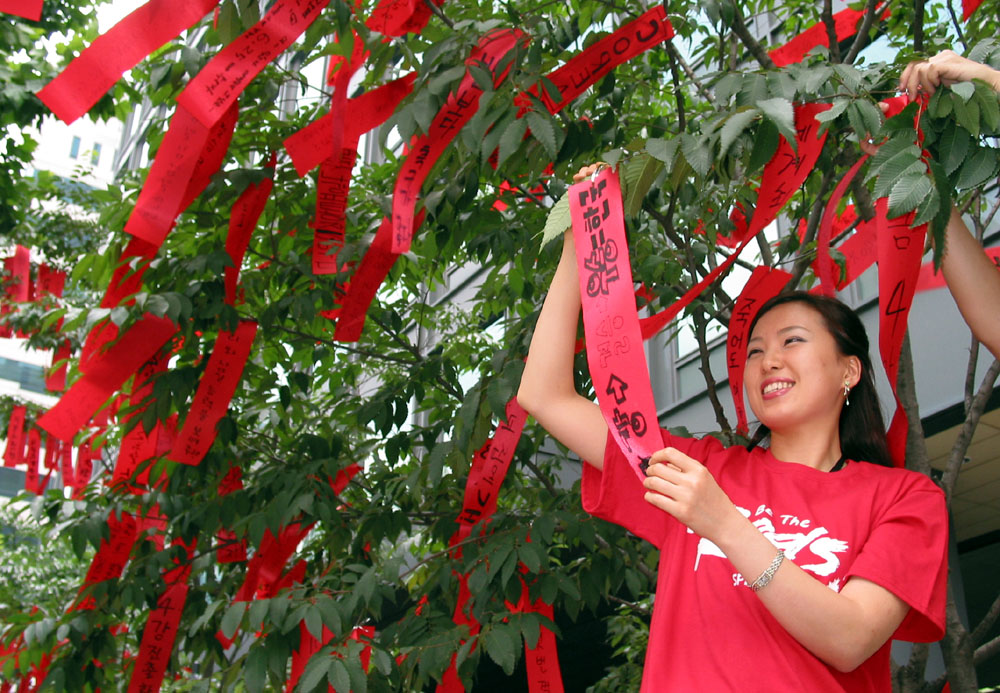 On June 21st, 2002, SK Telecom held an event in which the company`s employee hung ribbons on the roadside trees in front of SK Telecom`s headquarters building. The ribbons contain a message of supplication that the Korean soccer team go into the semi-final competition in the World Cup. The photo shows SK Telecom employees hanging ribbons on the roadside trees.